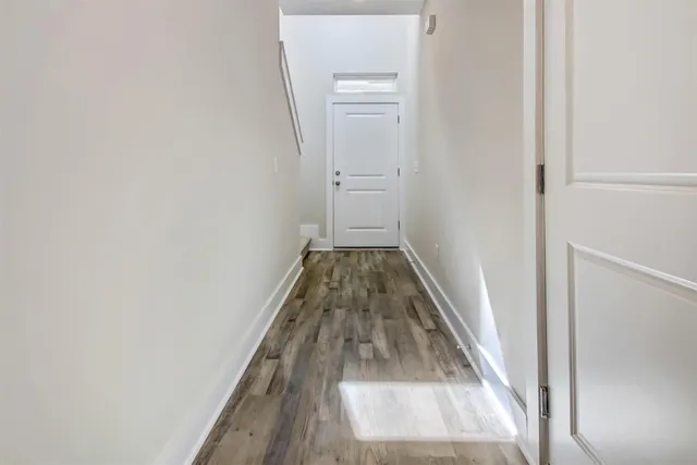 a view of a hallway with wooden floor