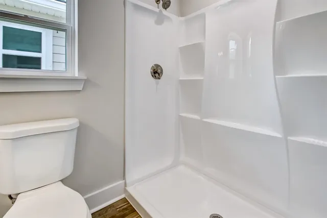 a bathroom with a toilet and a shower