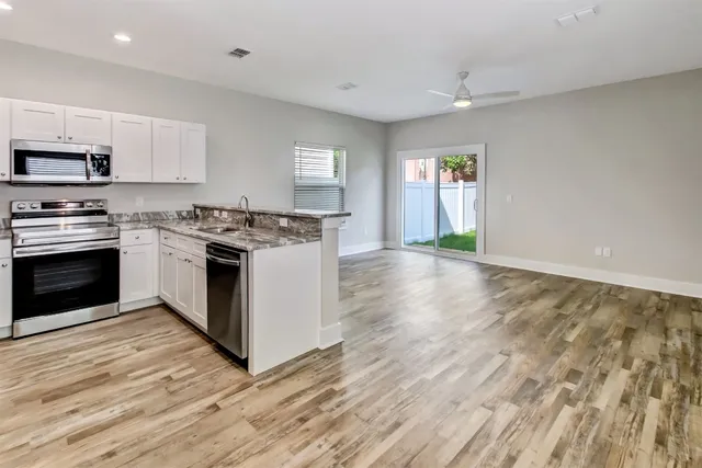 a kitchen with stainless steel appliances granite countertop a stove top oven and sink