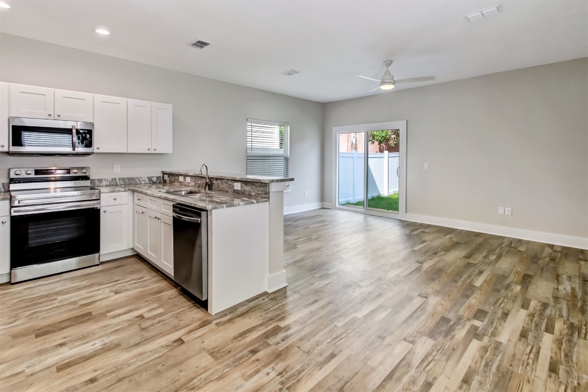926 South 7th Street Fernandina Beach, FL 32034 - Photo 3 of 37 a kitchen with stainless steel appliances granite countertop a stove top oven and sink