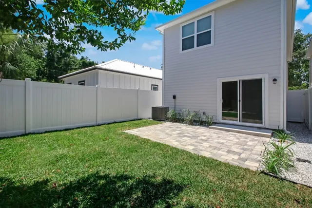 a backyard of a house with plants and tree