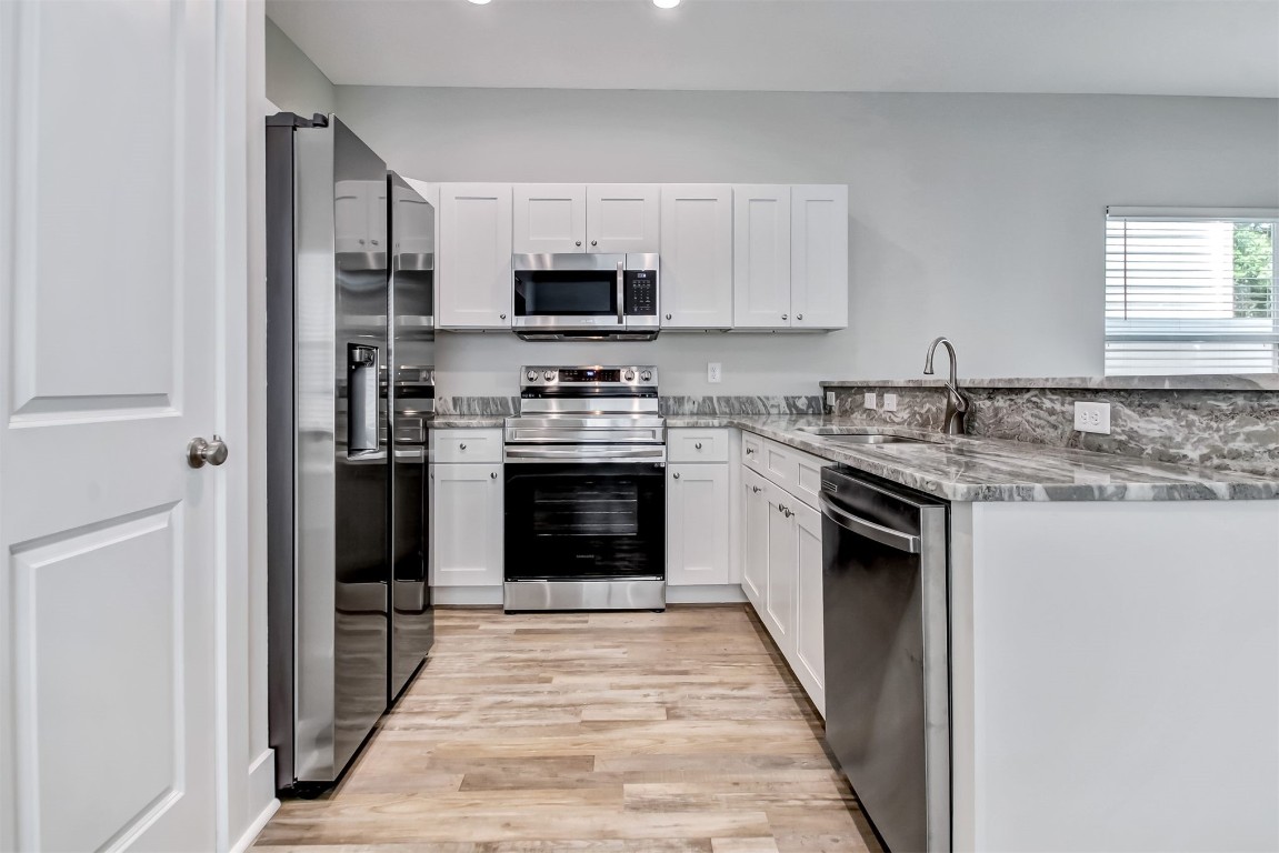 926 South 7th Street Fernandina Beach, FL 32034 - Photo 6 of 37 a kitchen with stainless steel appliances granite countertop a stove top oven a sink and a refrigerator