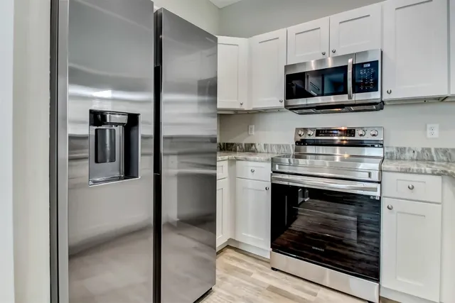 a kitchen with stainless steel appliances a stove microwave and sink