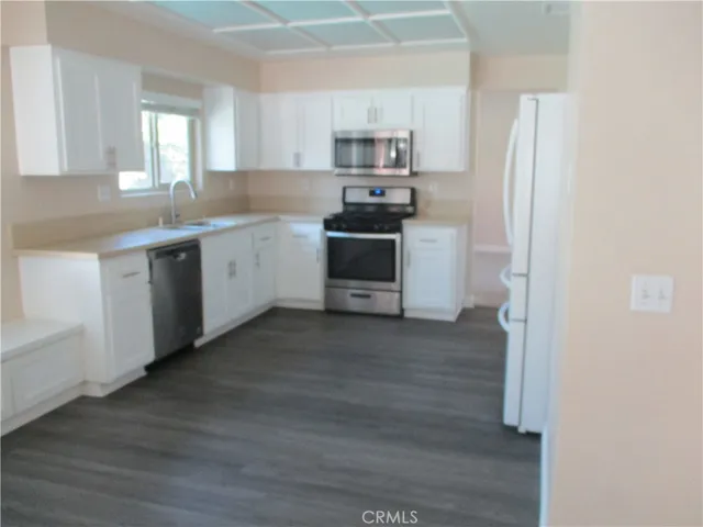 a kitchen with a refrigerator stove top oven and sink