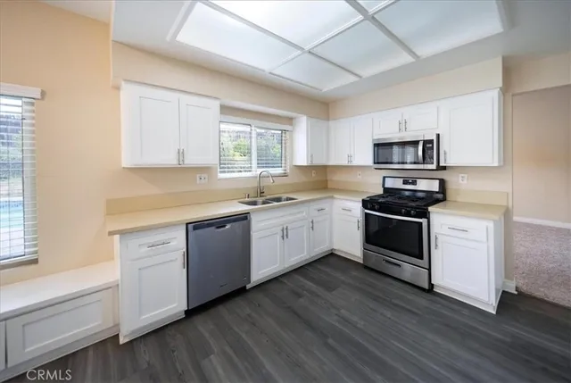 a kitchen with granite countertop white cabinets and white appliances