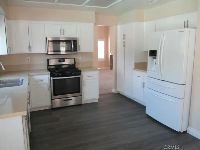 a kitchen with white cabinets and stainless steel appliances
