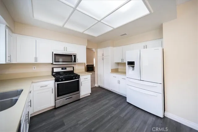 a kitchen with white cabinets and stainless steel appliances