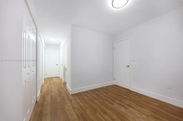 a view of a room with wooden floor and white walls