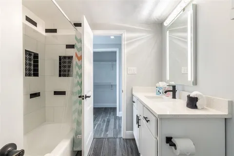 a bathroom with a double vanity sink a mirror and a bathtub