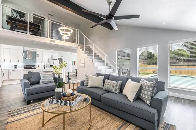 a living room with furniture kitchen view and a large window