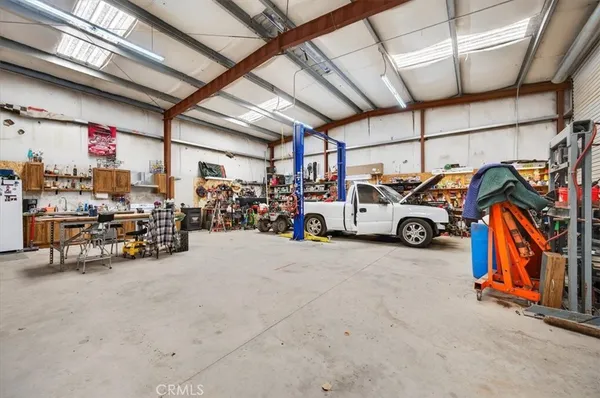 a living room with stainless steel appliances kitchen island granite countertop furniture and a refrigerator