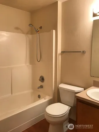 a white toilet sitting next to a bath tub and a shower