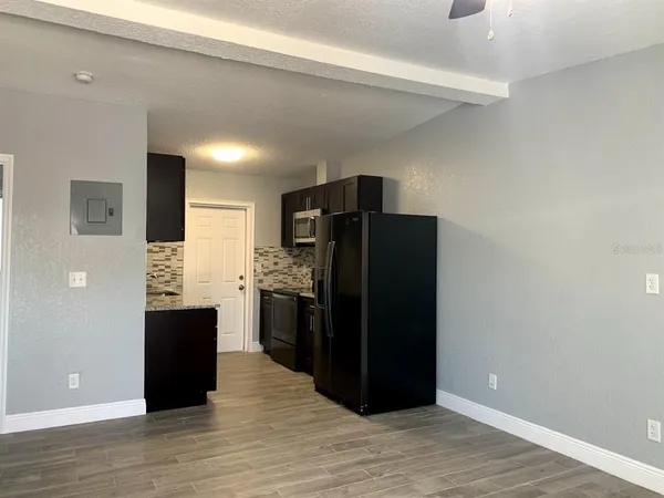 a view of kitchen with refrigerator and wooden floor