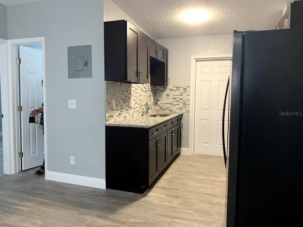 a kitchen with stainless steel appliances kitchen island granite countertop a refrigerator and a sink
