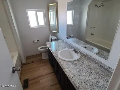 a bathroom with a granite countertop sink and a mirror