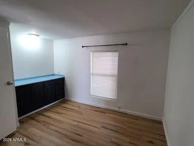 a view of empty room with wooden floor