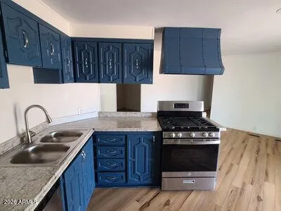 a kitchen with granite countertop a stove sink and cabinets