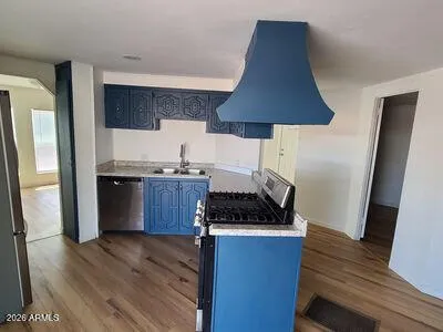 a kitchen with granite countertop a stove and a wooden floor