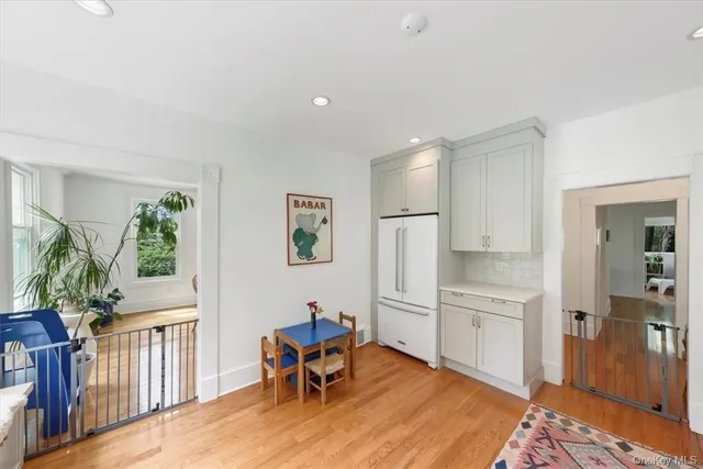a kitchen with white cabinets and wooden floor