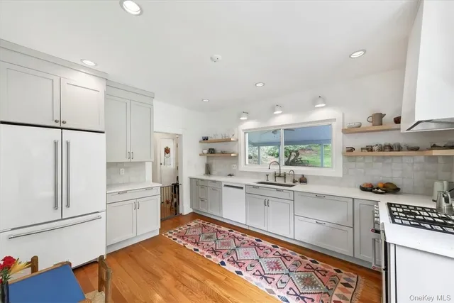 a kitchen with white cabinets and appliances