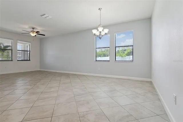 an empty room with windows and ceiling fan