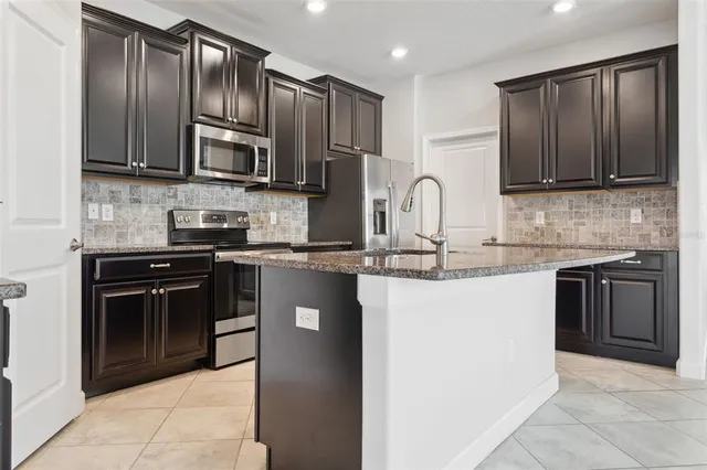 a kitchen with stainless steel appliances granite countertop wooden cabinets a stove a sink and dishwasher