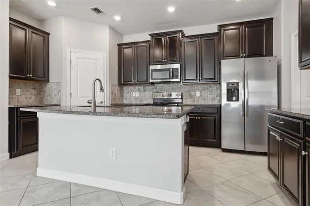 a kitchen with stainless steel appliances granite countertop a refrigerator and a sink