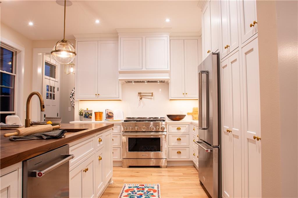 212 South Mathilda Street Pittsburgh, PA 15224 - Photo 12 of 38 a kitchen with stainless steel appliances granite countertop a stove a sink dishwasher and a refrigerator with wooden floor