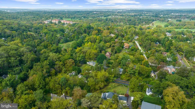 an aerial view of residential houses with outdoor space and trees all around