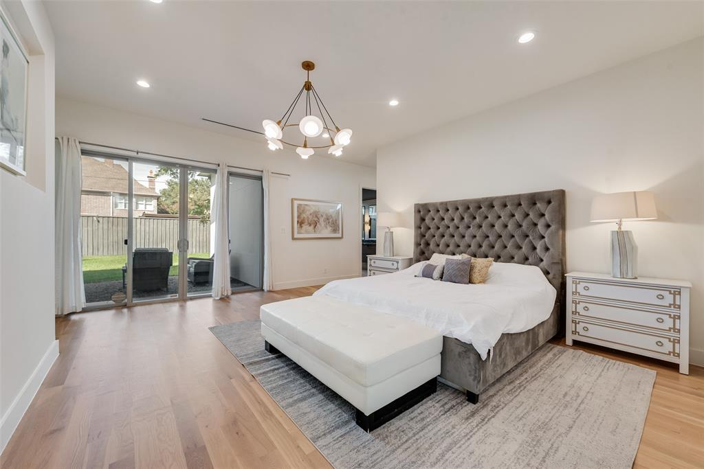 6411 Royal Lane Dallas, TX 75230 - Photo 15 of 35 a bedroom with a large bed and a chandelier