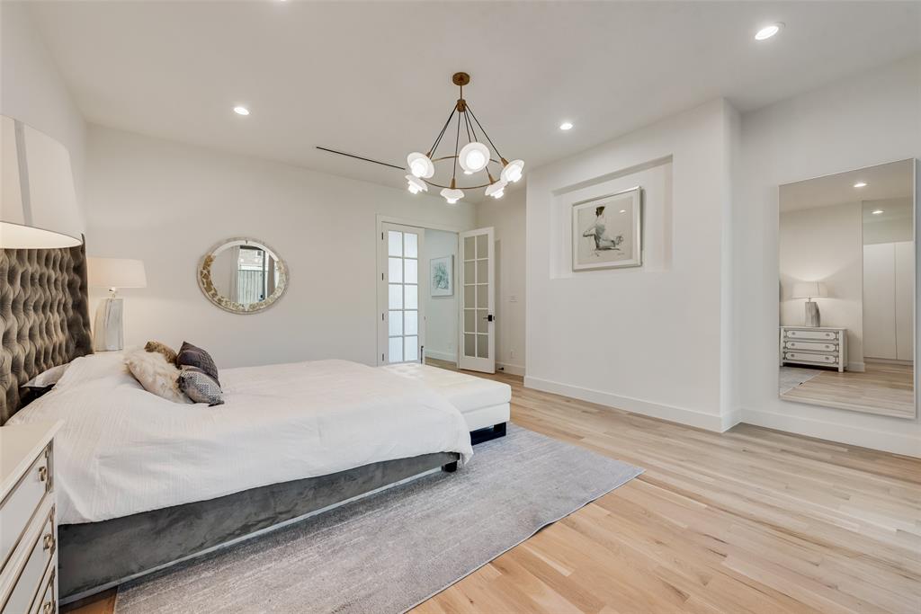 6411 Royal Lane Dallas, TX 75230 - Photo 16 of 35 a bedroom with a bed and a chandelier