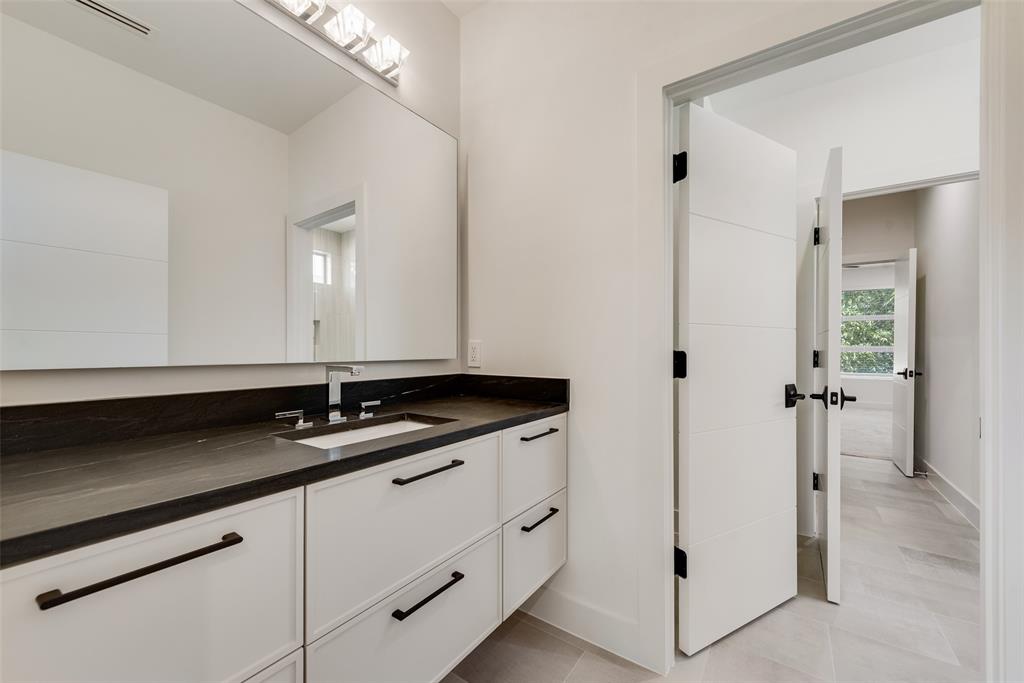 6411 Royal Lane Dallas, TX 75230 - Photo 24 of 35 a bathroom with a granite countertop sink and a mirror