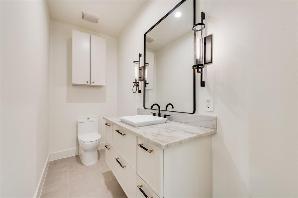 6411 Royal Lane Dallas, TX 75230 - Photo 30 of 35 a bathroom with a granite countertop sink toilet and mirror