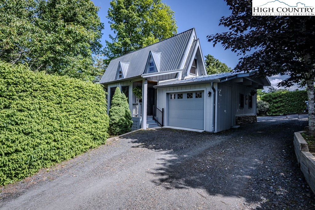 a view of a house with a small yard and a large tree