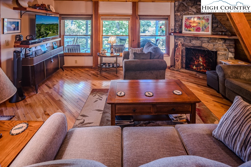 183 Rhododendron Loop Newland, NC 28657 - Photo 13 of 49 a living room with furniture a flat screen tv and a fireplace
