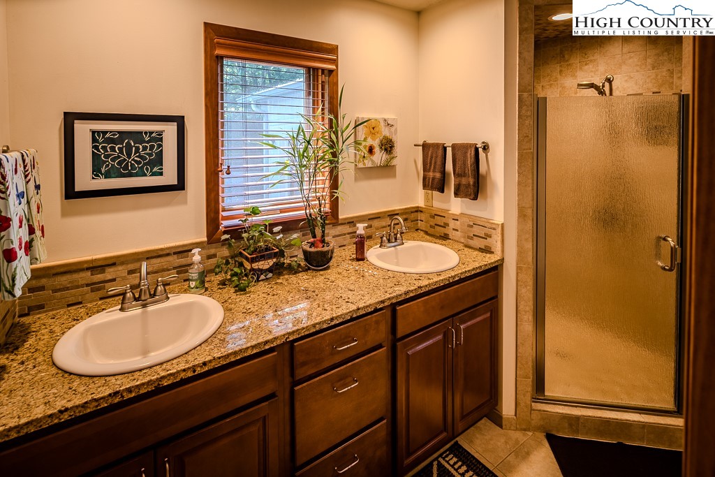 183 Rhododendron Loop Newland, NC 28657 - Photo 25 of 49 a bathroom with a granite countertop sink and a mirror