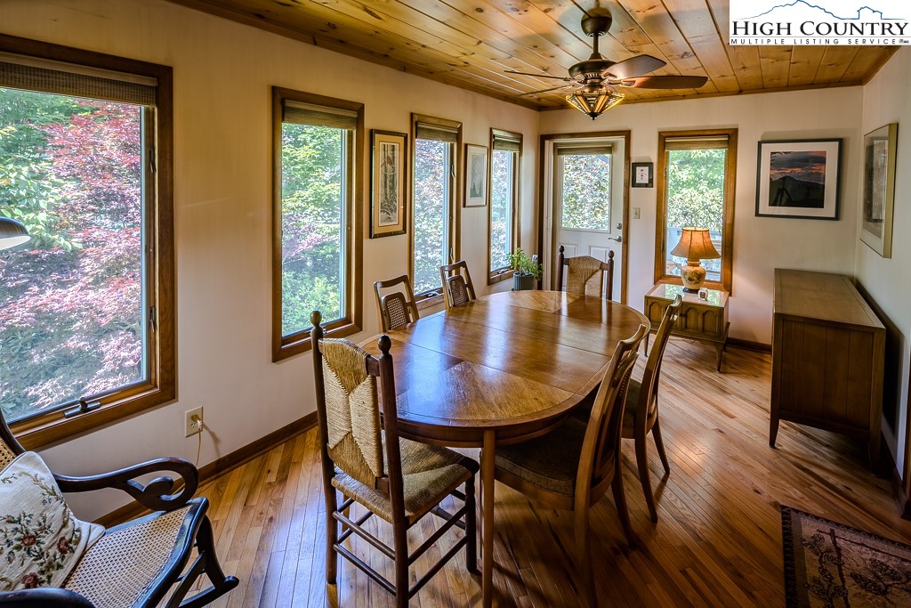 183 Rhododendron Loop Newland, NC 28657 - Photo 7 of 49 a view of a dining room with furniture a chandelier and wooden floor