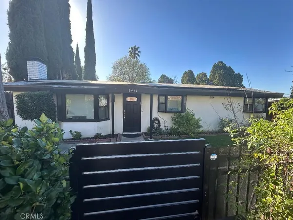 a front view of a house with plants