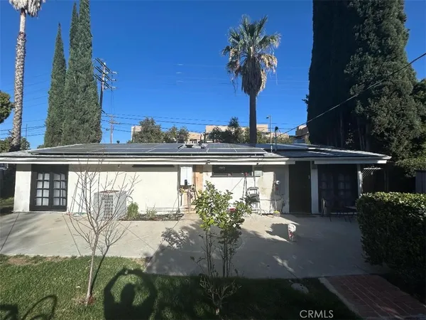 a view of a house with a yard and potted plants