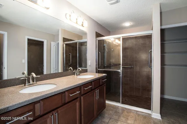 a bathroom with a granite countertop sink shower and a mirror
