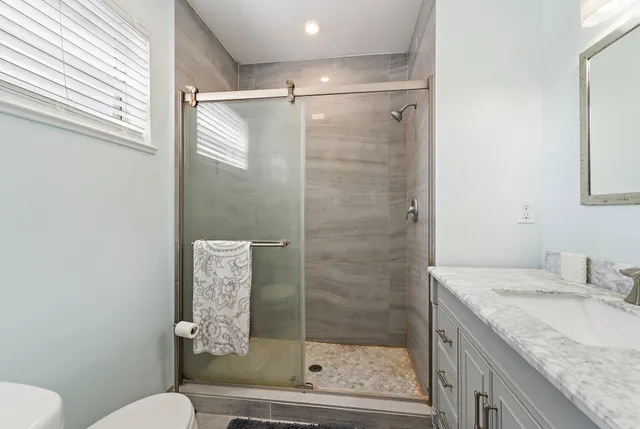 a bathroom with a granite countertop sink toilet and shower