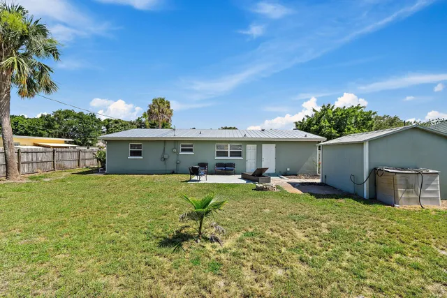 a view of a house with backyard and sitting area