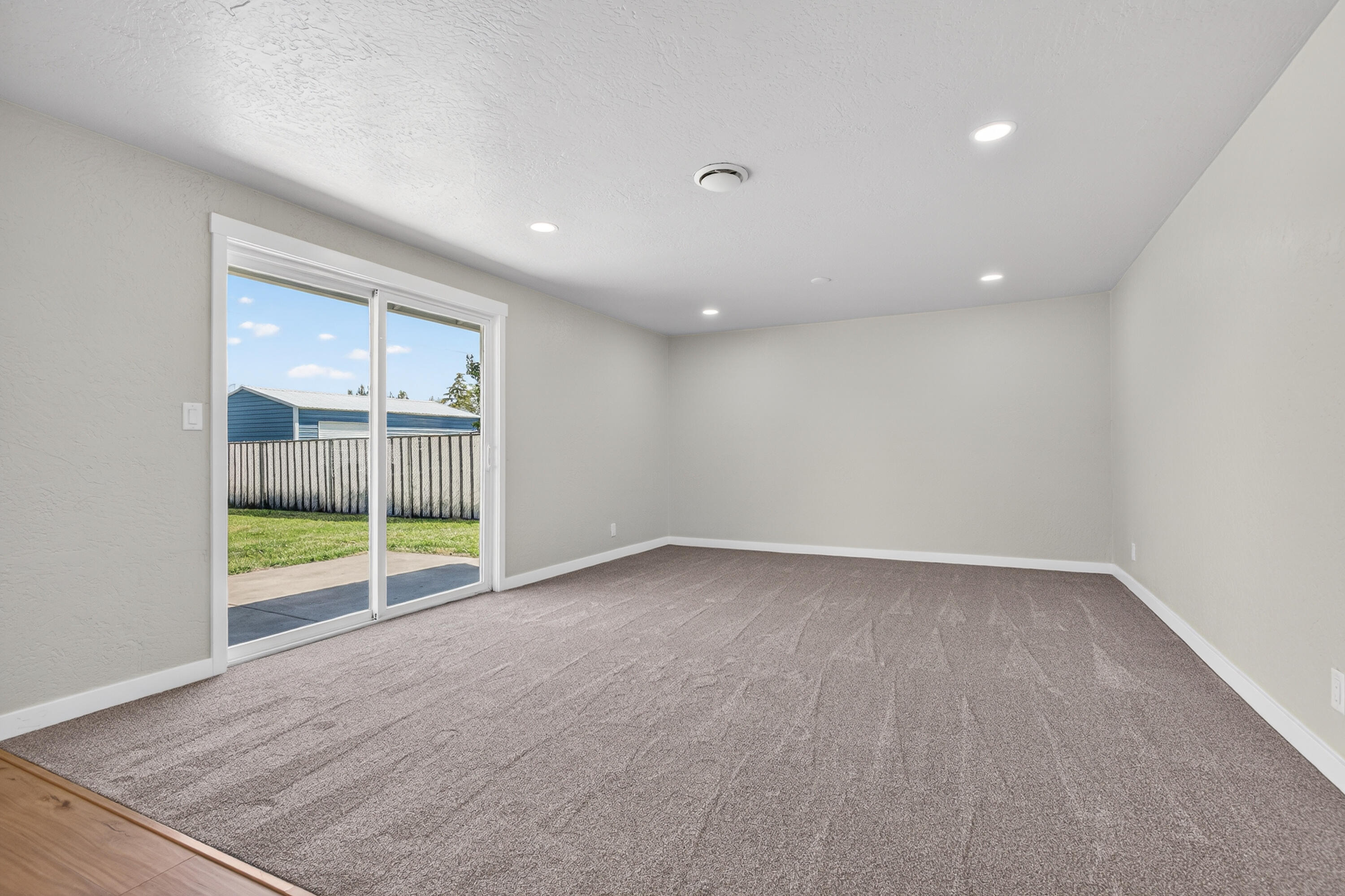 550 Experiment Station Road Medford, OR 97501 - Photo 6 of 27 an empty room with sliding glass door and glass door
