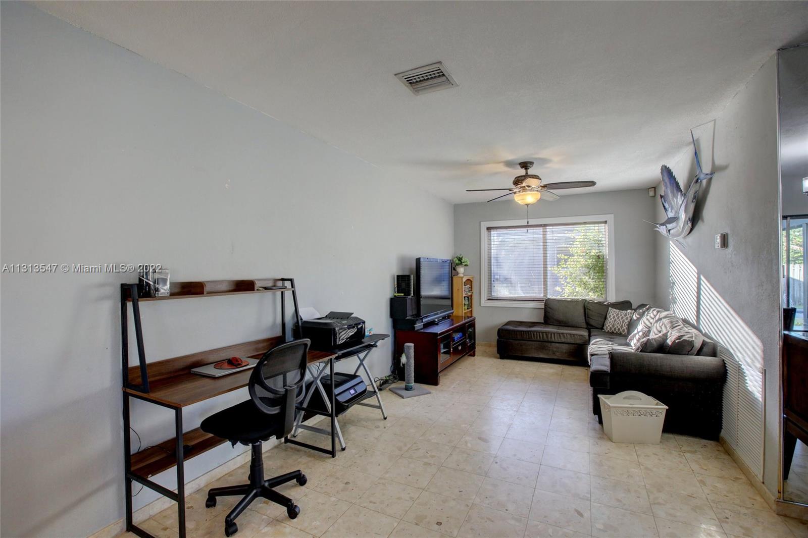 6681 Peters Road Plantation, FL 33317 - Photo 11 of 27 a living room with furniture and a chandelier