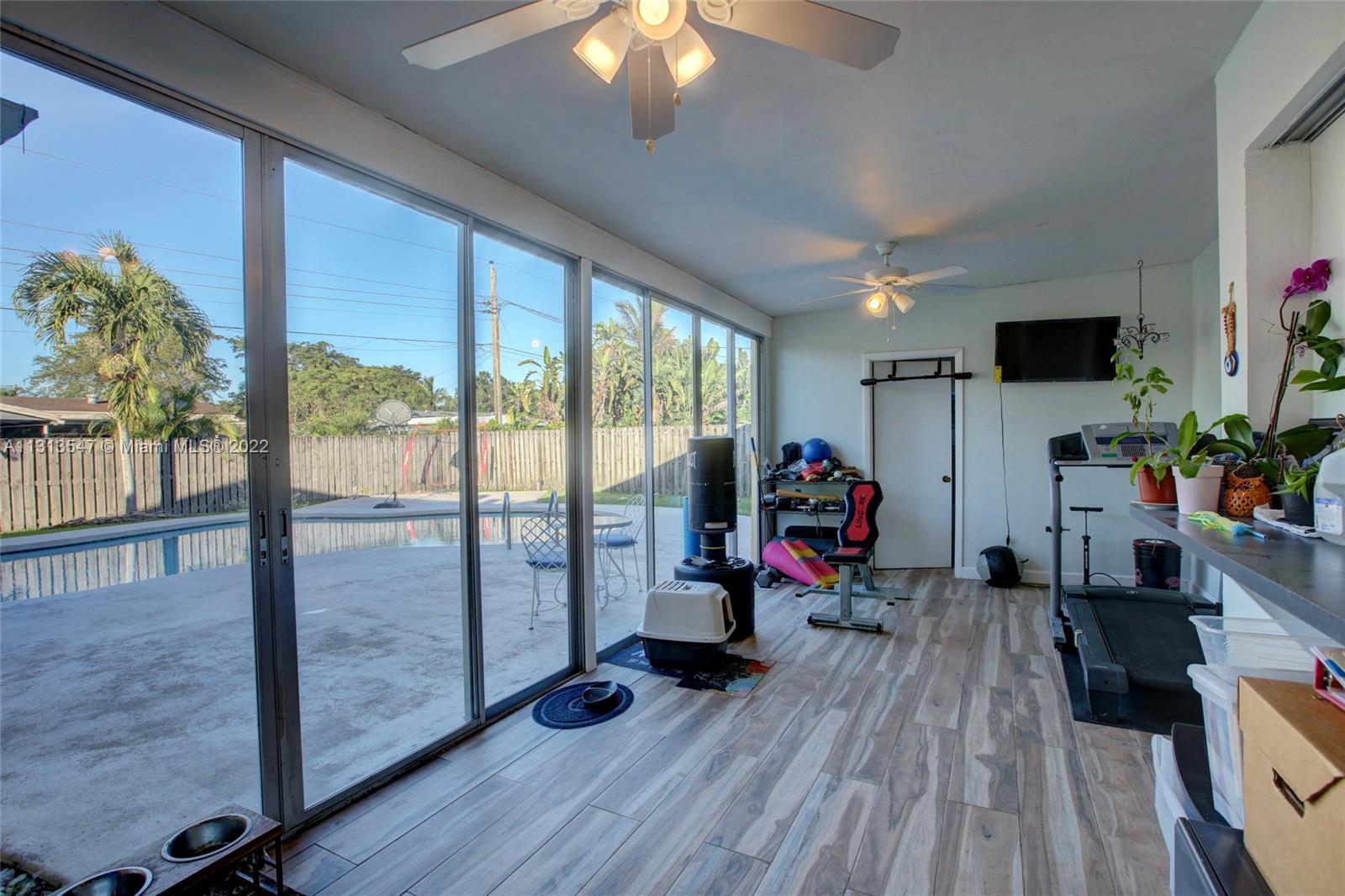 6681 Peters Road Plantation, FL 33317 - Photo 17 of 27 a view of a livingroom with furniture gym equipment and a large window