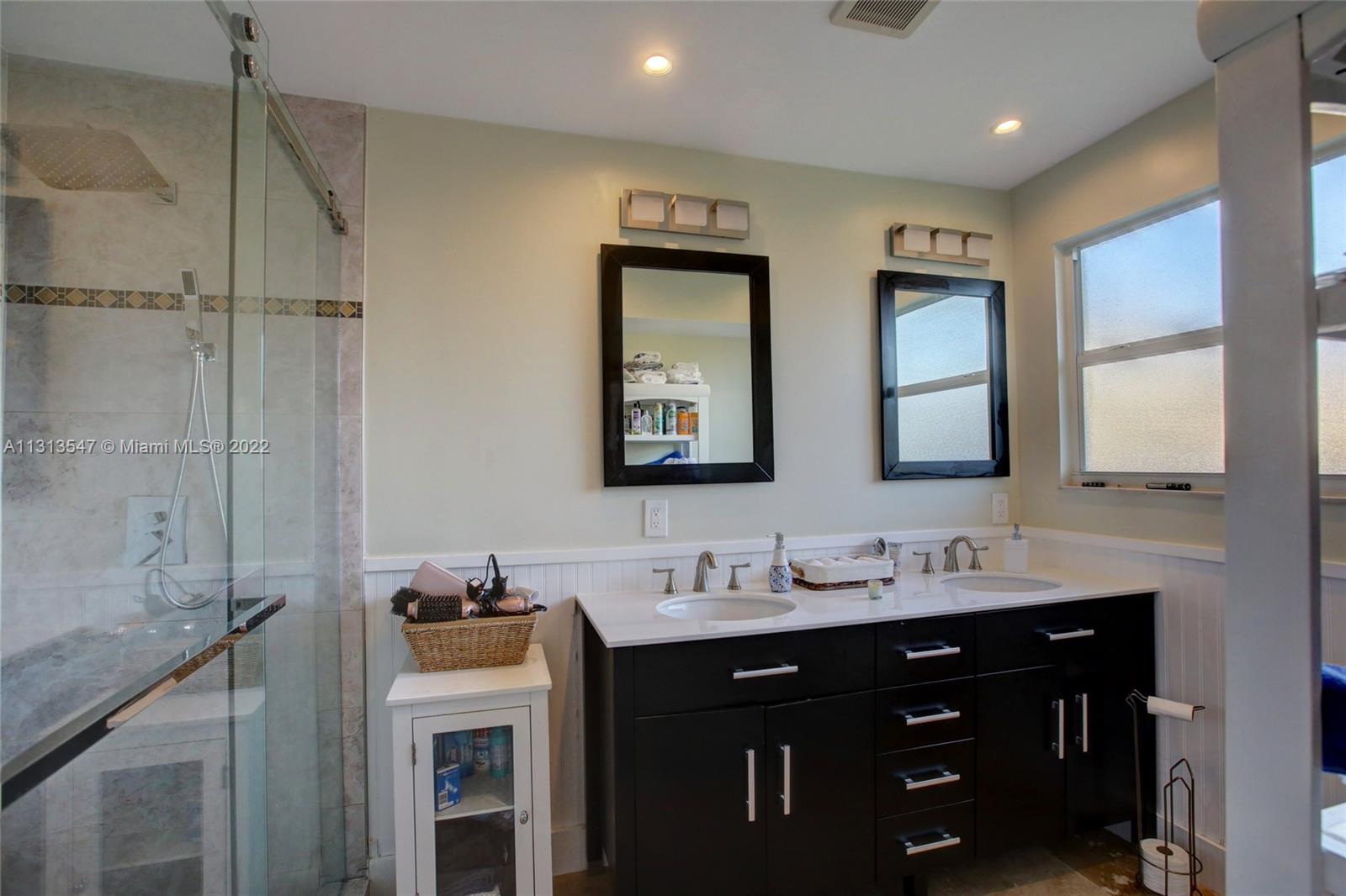 6681 Peters Road Plantation, FL 33317 - Photo 24 of 27 a bathroom with a double vanity sink and mirror