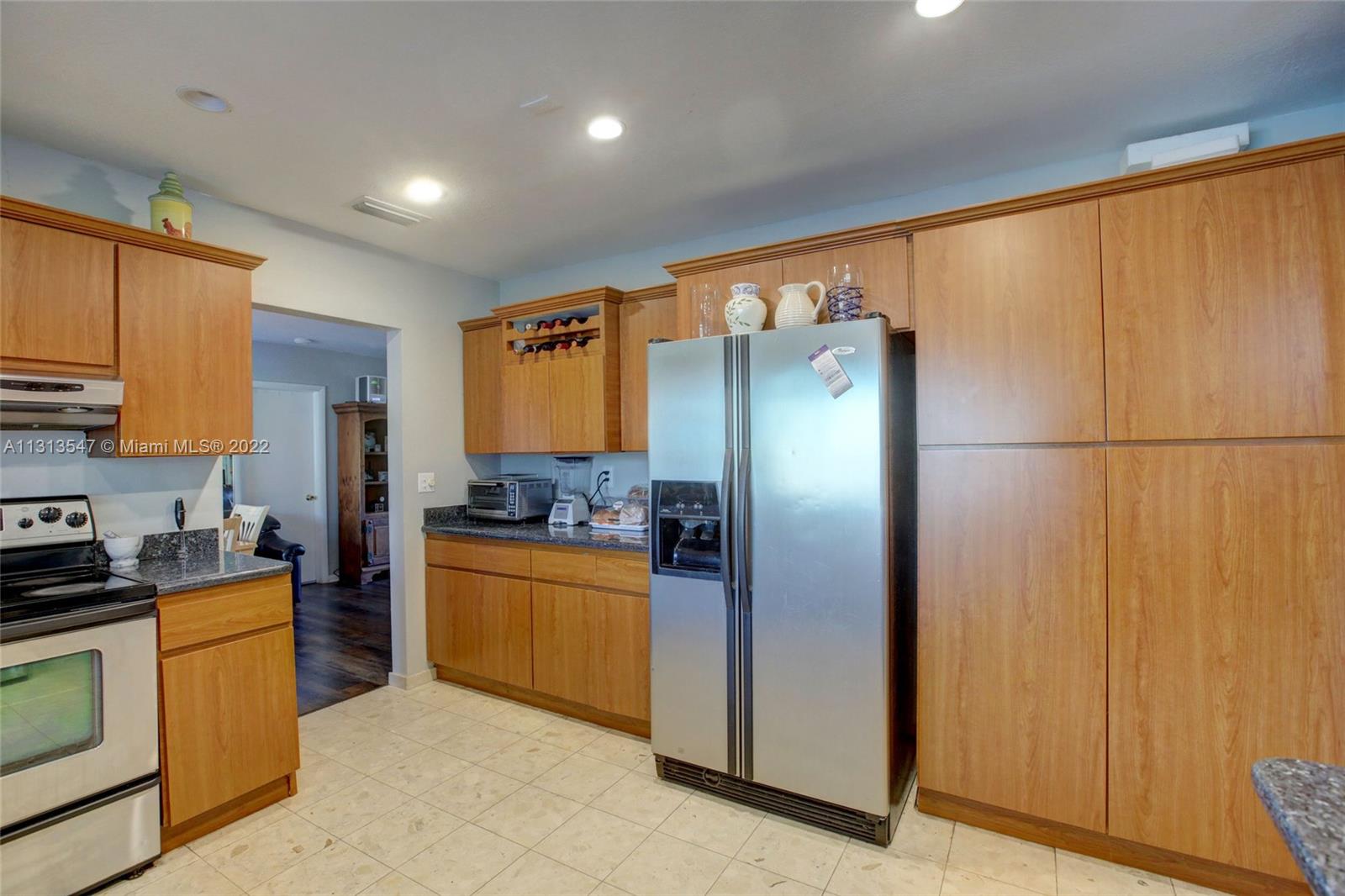 6681 Peters Road Plantation, FL 33317 - Photo 9 of 27 a kitchen with stainless steel appliances granite countertop a refrigerator and a stove top oven