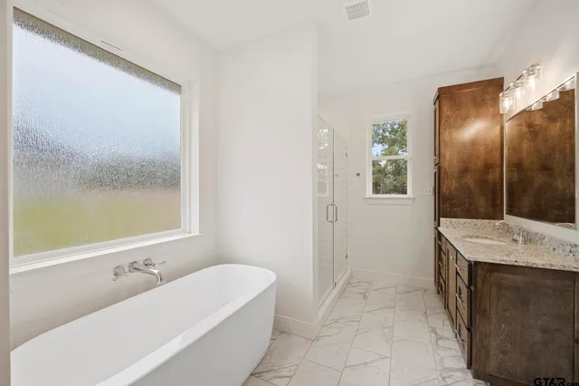 a bathroom with a tub sink and mirror