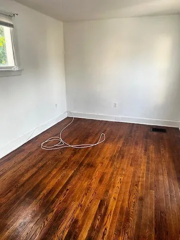a view of a room with wooden floor and white walls