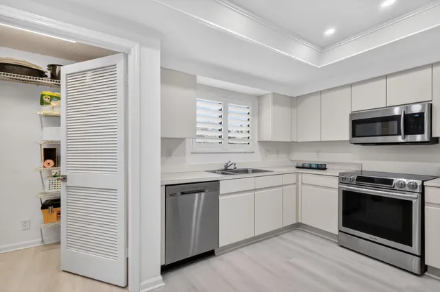 a kitchen with stainless steel appliances granite countertop a refrigerator stove a sink and a microwave